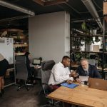 Equipe diversa reunida em um escritório moderno, colaborando em uma discussão de planejamento.