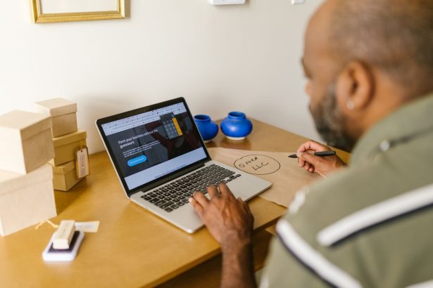 Empreendedor trabalha ao laptop em uma mesa, planejando atividades de negócios em um ambiente de escritório.